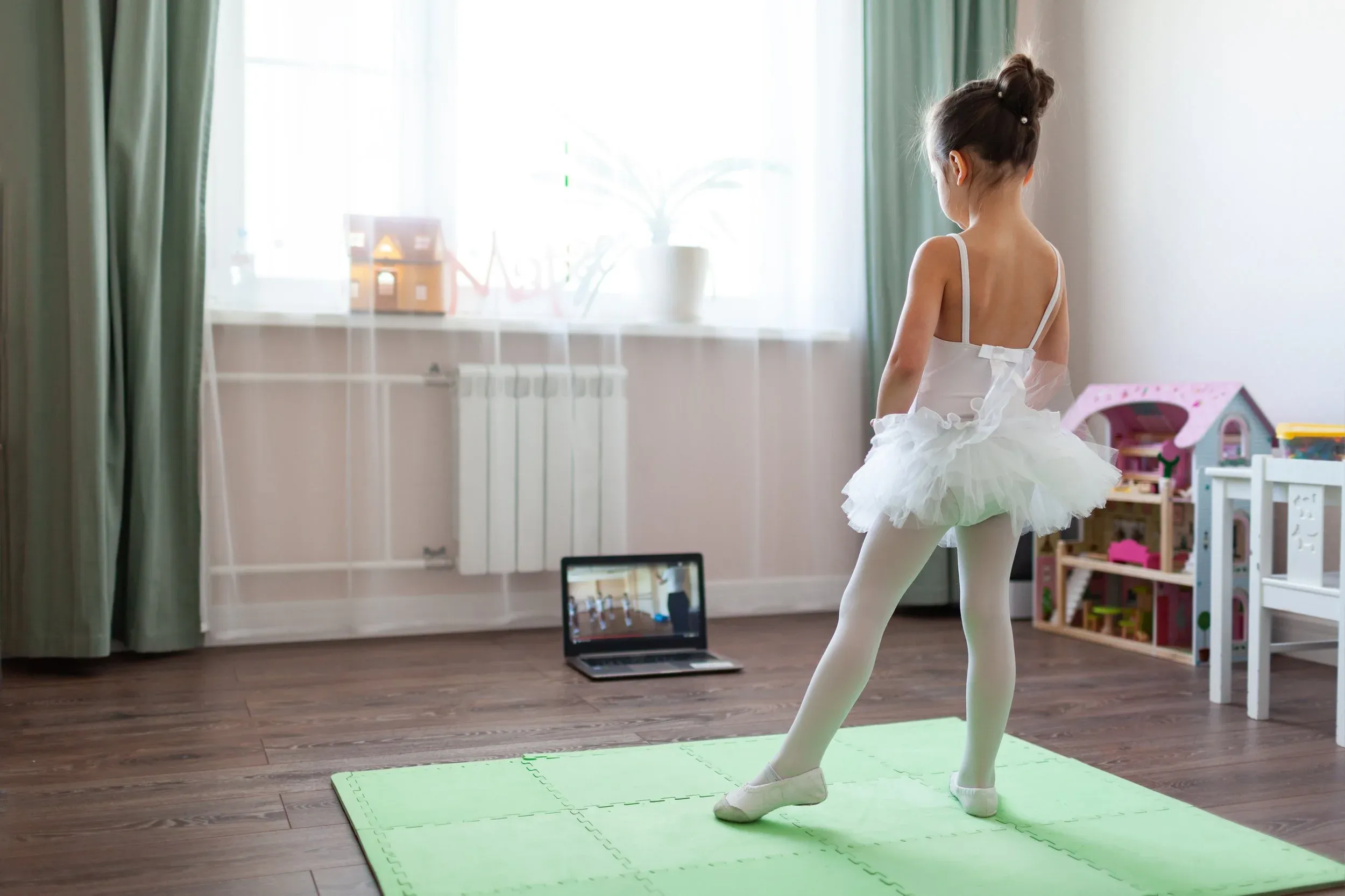 A young ballerina following a YouDance lesson at home